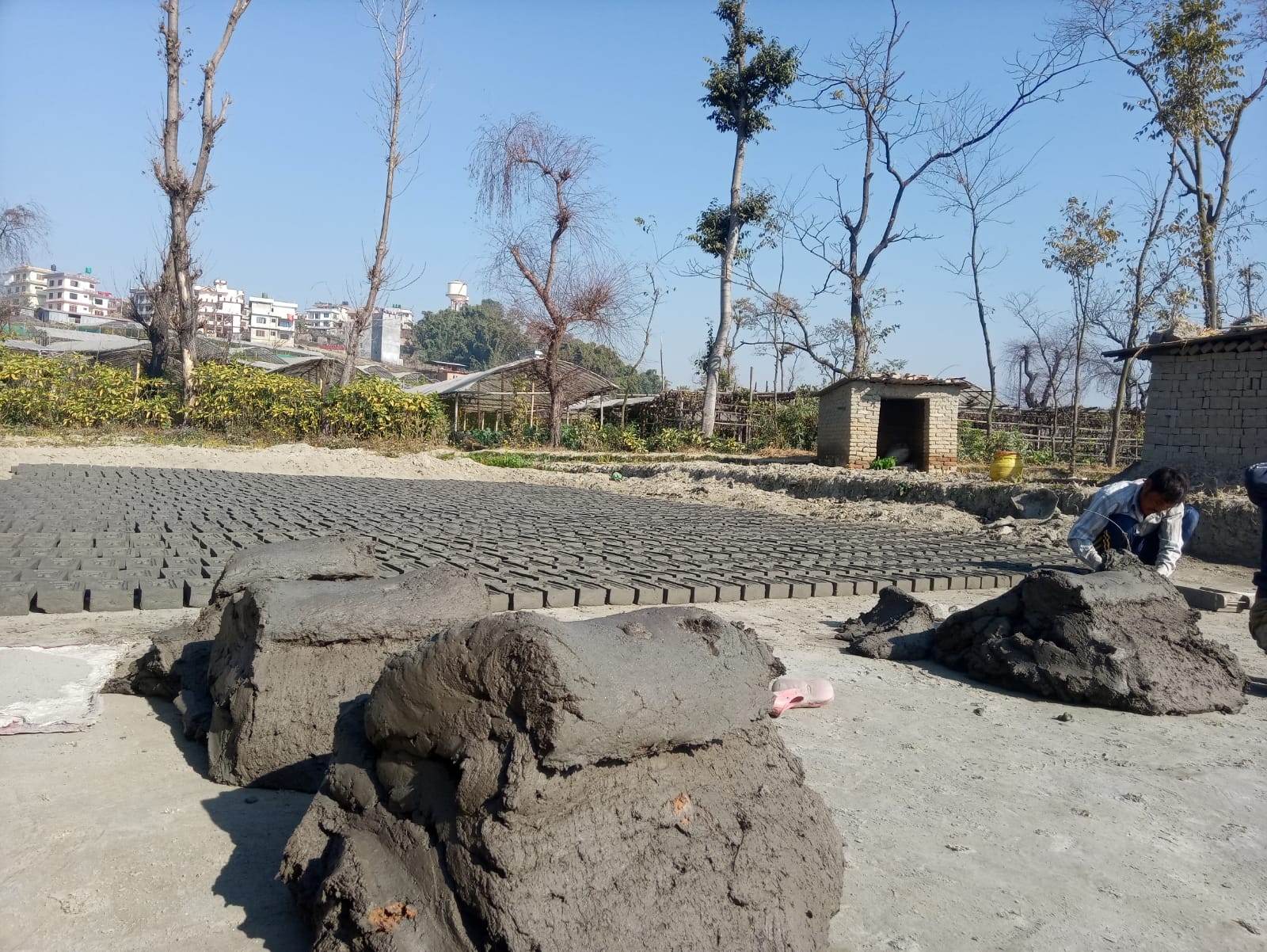 तस्बिरमा इट्टा बनाउन व्यस्त मजदुरहरू